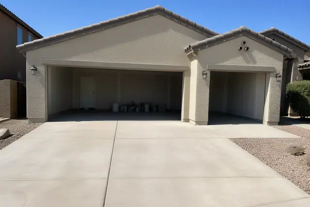 Single and double garage door openings on a residential home with desert landscaping in Phoenix, AZ.