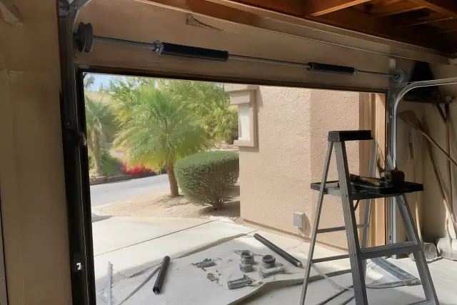 Garage door spring and track repair in progress inside a residential garage in Phoenix, AZ.