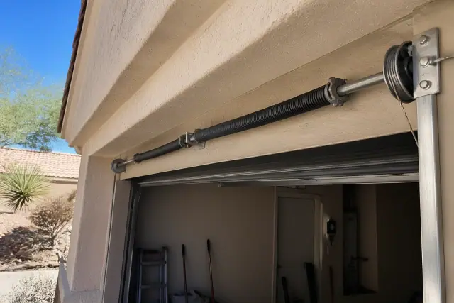 Torsion springs and cable drums on a garage door shaft at a home in Phoenix, AZ.