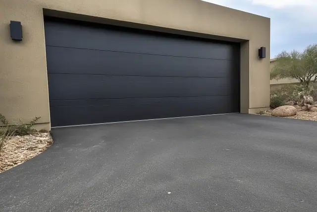 Steel garage doors installed on a residential home with desert landscaping in Phoenix, AZ.