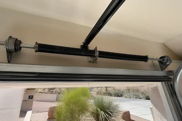 Torsion springs and cable drums on a garage door shaft at a home in Phoenix, AZ.