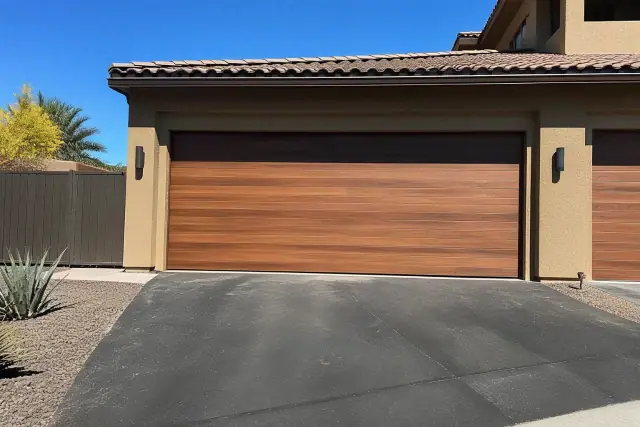 New wood garage doors installed at a residential home with desert landscaping in Phoenix, AZ.