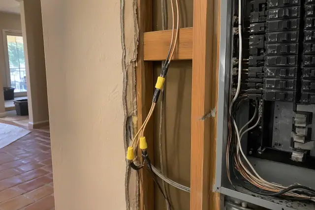 Copper wiring spliced to aluminum wire near wooden studs during a panel upgrade in Phoenix, AZ.