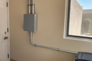 Finished electrical junction and secured wiring conduit on repaired drywall in Phoenix, AZ.