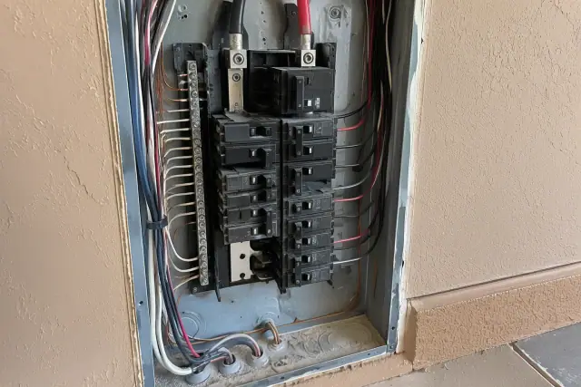Open electrical service panel with a newly installed breaker switch in Phoenix, AZ.