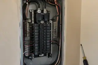 Open electrical service panel with switches and wires in Phoenix, AZ.