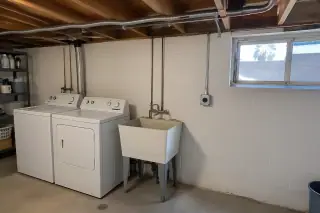 Armored cable running along basement floor joists to a dedicated receptacle in Phoenix, AZ.