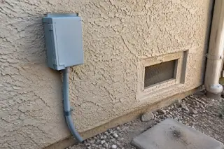 Desert-tan exterior stucco wall and foundation vent in Phoenix, AZ.