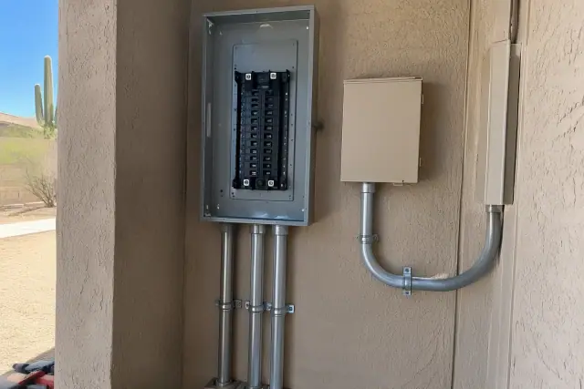Electrical panel upgrade and new conduit in a Phoenix, AZ residential utility alcove.
