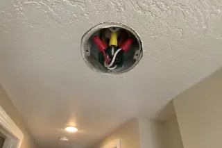 Open ceiling junction box with secured wire nuts and colored conductors in Phoenix, AZ.