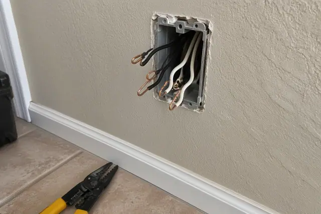 Exposed copper wires inside an electrical wall box during whole house rewiring in Mesa, AZ.