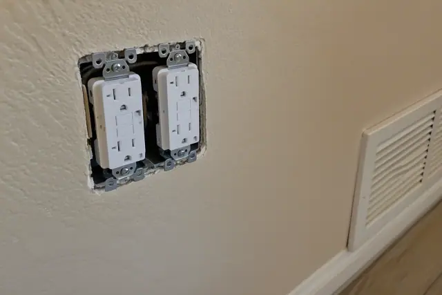 Tamper-resistant duplex receptacles wired in a beige stucco wall during a whole house rewiring in Surprise, AZ.