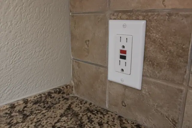 GFCI receptacle and exposed wires beside a kitchen countertop in Phoenix, AZ.