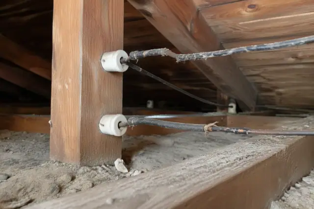 Knob-and-tube wiring with frayed insulation and ceramic knobs in an attic in Phoenix, AZ.