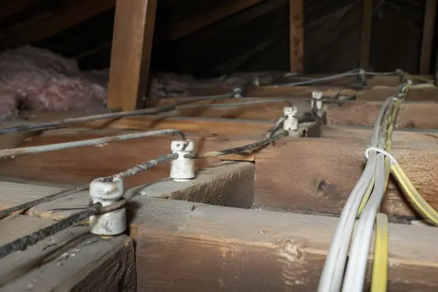 Old knob and tube wiring and modern cables in an attic in Surprise, AZ.