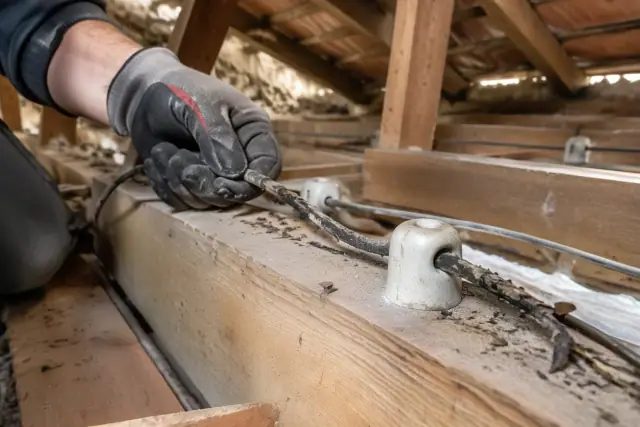 Attic whole house rewiring in Scottsdale, AZ, showing active extraction of old knob and tube wiring.