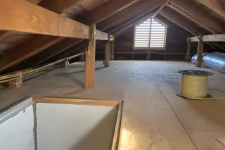 Modern NM-B cables routed safely past attic framing with a spare wire spool in Phoenix, AZ.