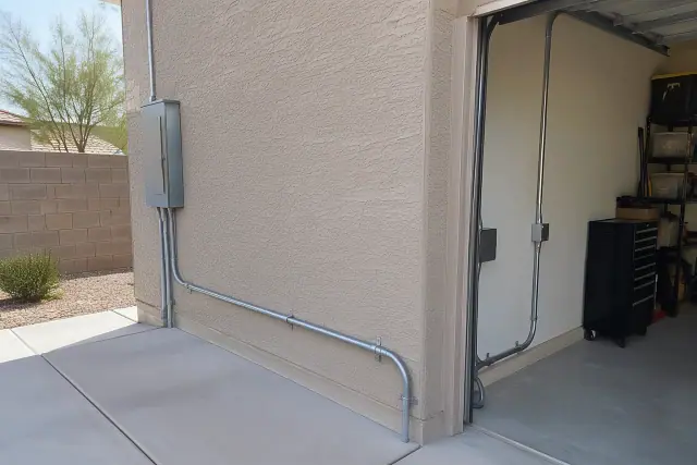 Conduit installed on a stucco exterior wall for dedicated circuit wiring in Phoenix, AZ.