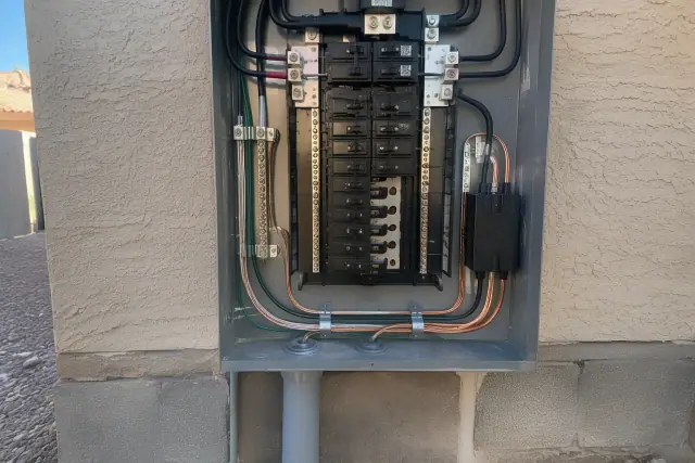 Whole-home surge protector installed in an electrical box on a stucco wall in Surprise, AZ.