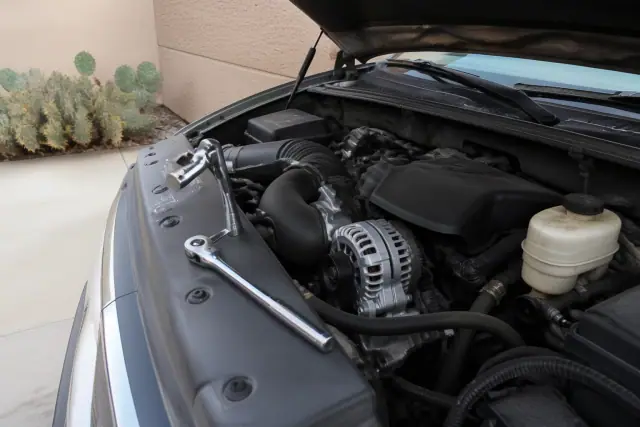 New alternator installed in an engine bay during a mobile mechanic service in a residential driveway in Surprise, AZ.