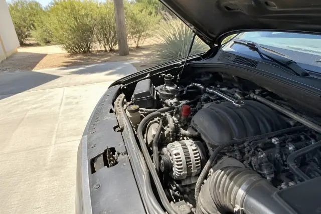 A new alternator installed in a car engine bay on a residential driveway in Tempe, AZ.