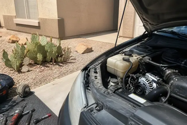 New alternator installed in an engine bay during a mobile mechanic service at a home in Mesa, AZ.