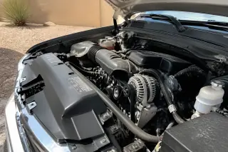 New alternator and drive belt installed in an open engine bay at a jobsite in Phoenix, AZ.