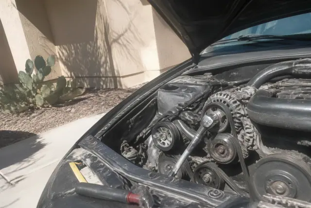 Serpentine belt and tensioner replacement on a vehicle in a residential driveway in Phoenix, AZ.