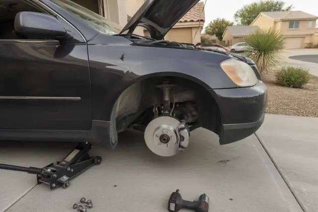 A vehicle with its wheel removed and new brake components installed during a mobile repair in a Peoria, AZ driveway.