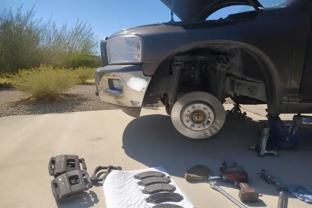 Brake repair service on a car parked on a concrete pad at a home in Goodyear, AZ.