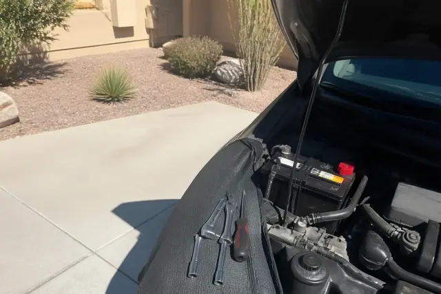 A new car battery installed in a vehicle parked on a concrete pad at a home in Glendale, AZ.