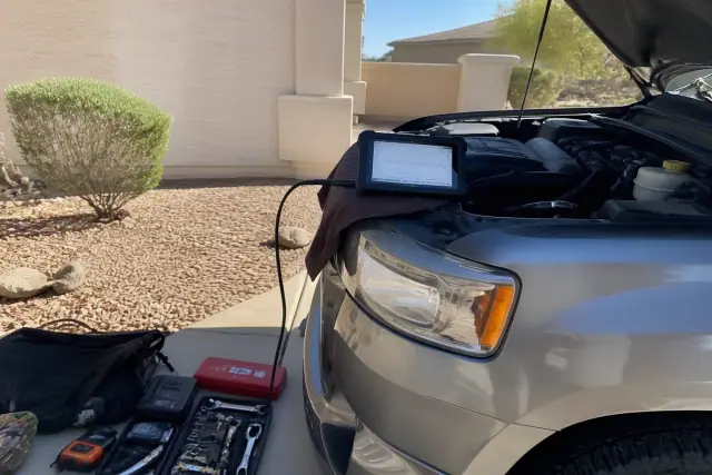 Mobile mechanic performing check engine light diagnostics on a car in a residential driveway in Surprise, AZ.