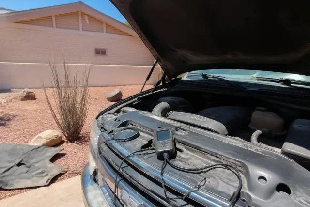 OBDII scanner plugged into a vehicle engine bay during a diagnostic service at a home in Phoenix, AZ.