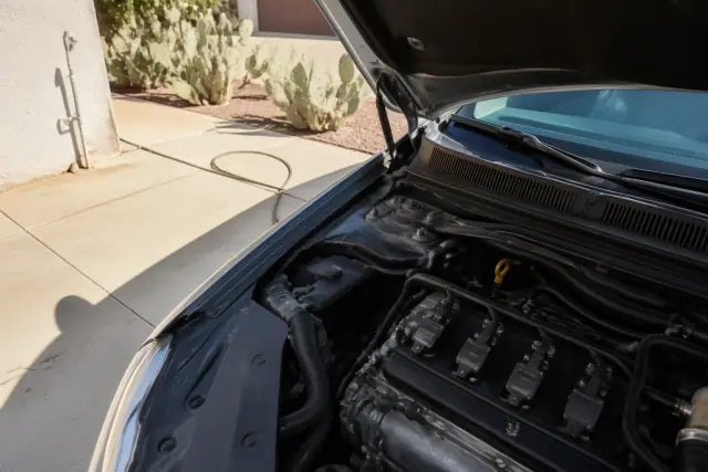 New ignition coils installed in a vehicle engine bay at a residential driveway in Phoenix, AZ.