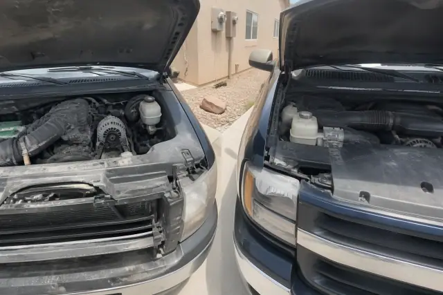 Two open vehicle engine bays on a concrete pad with desert landscaping at a home in Phoenix, AZ.