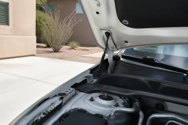 A vehicle with its hood raised during a pre-purchase inspection on a driveway in Phoenix, AZ.