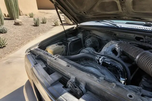 Radiator cooling system leak repair components installed in a vehicle engine bay at a job site in Phoenix, AZ.