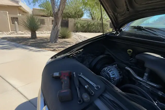 New alternator installed in a vehicle engine bay at a residence in Phoenix, AZ.