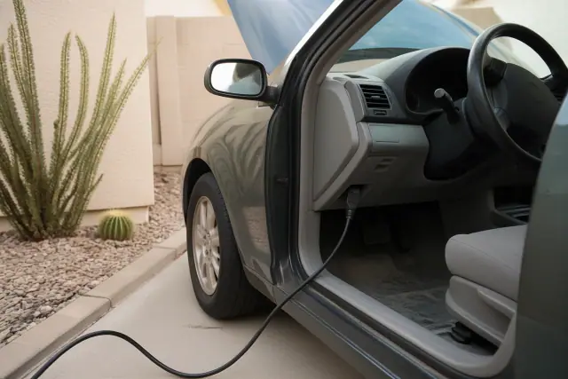 OBD2 diagnostic cable connected to a vehicle on a concrete pad at a home in Phoenix, AZ.