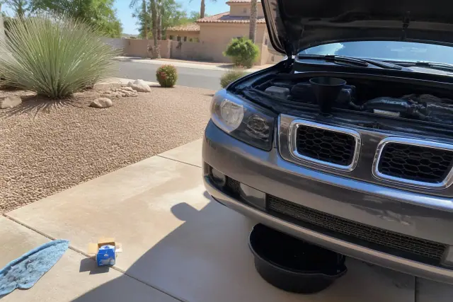 Vehicle undergoing an oil change in a residential driveway in Chandler, AZ.