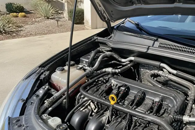 Platinum spark plugs and ignition coils installed in a vehicle engine bay at a home in Phoenix, AZ.