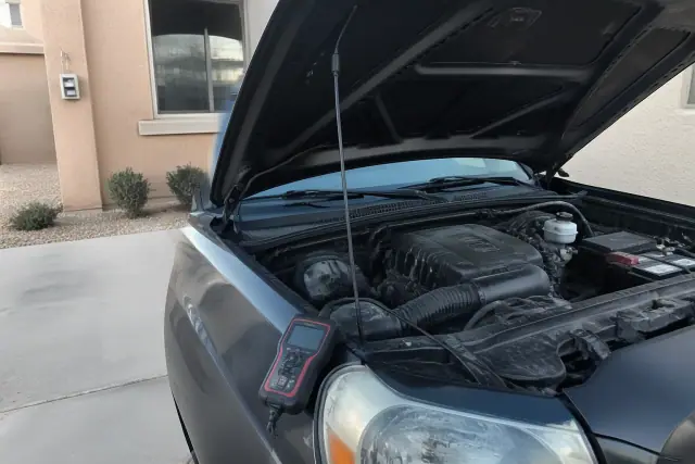 Mobile mechanic performing a car diagnostic scan with an OBDII scanner on a vehicle parked at a home in Surprise, AZ.