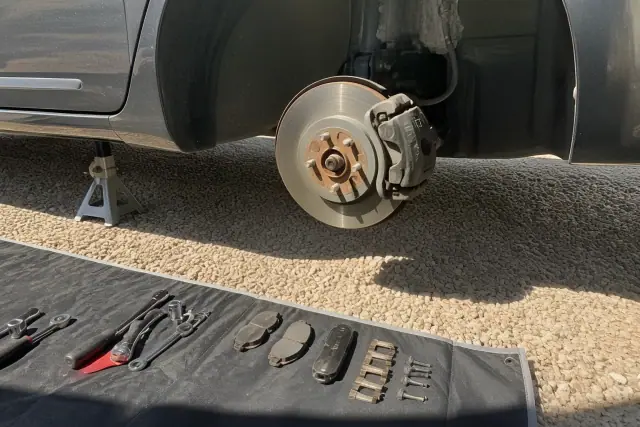 Brake assembly inspection on a car raised on jack stands in Phoenix, AZ.