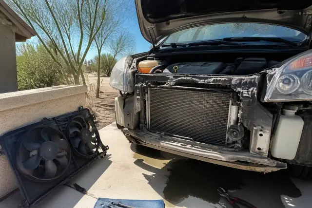 Mobile mechanic performing a radiator and cooling system repair on a car at a residential home in Tempe, AZ.