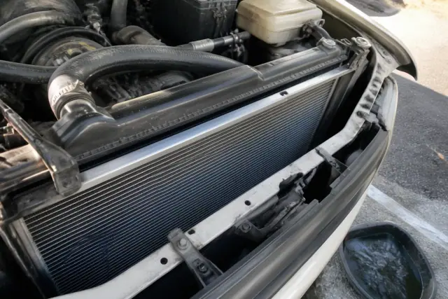 A new radiator installed in a car engine bay at an apartment complex parking lot in Glendale, AZ.