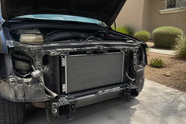 Mobile mechanic performing radiator and cooling system repair on a car in a residential driveway in Chandler, AZ.