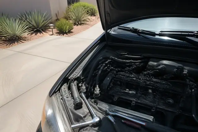 Spark plugs and ignition coils being replaced on a vehicle in a residential driveway in Gilbert, AZ.