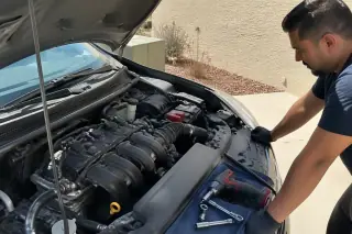 New spark plugs and ignition coils installed in a clean car engine bay in Phoenix, AZ.