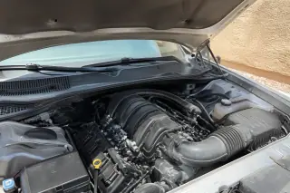 New ignition coils and routed cables installed in a car engine bay under bright desert sunlight in Phoenix, AZ.