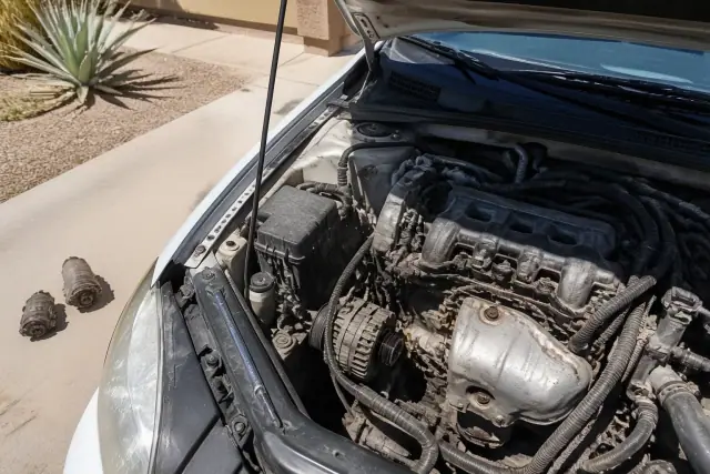 Mobile mechanic performing a starter replacement on a vehicle in a Peoria, AZ driveway.